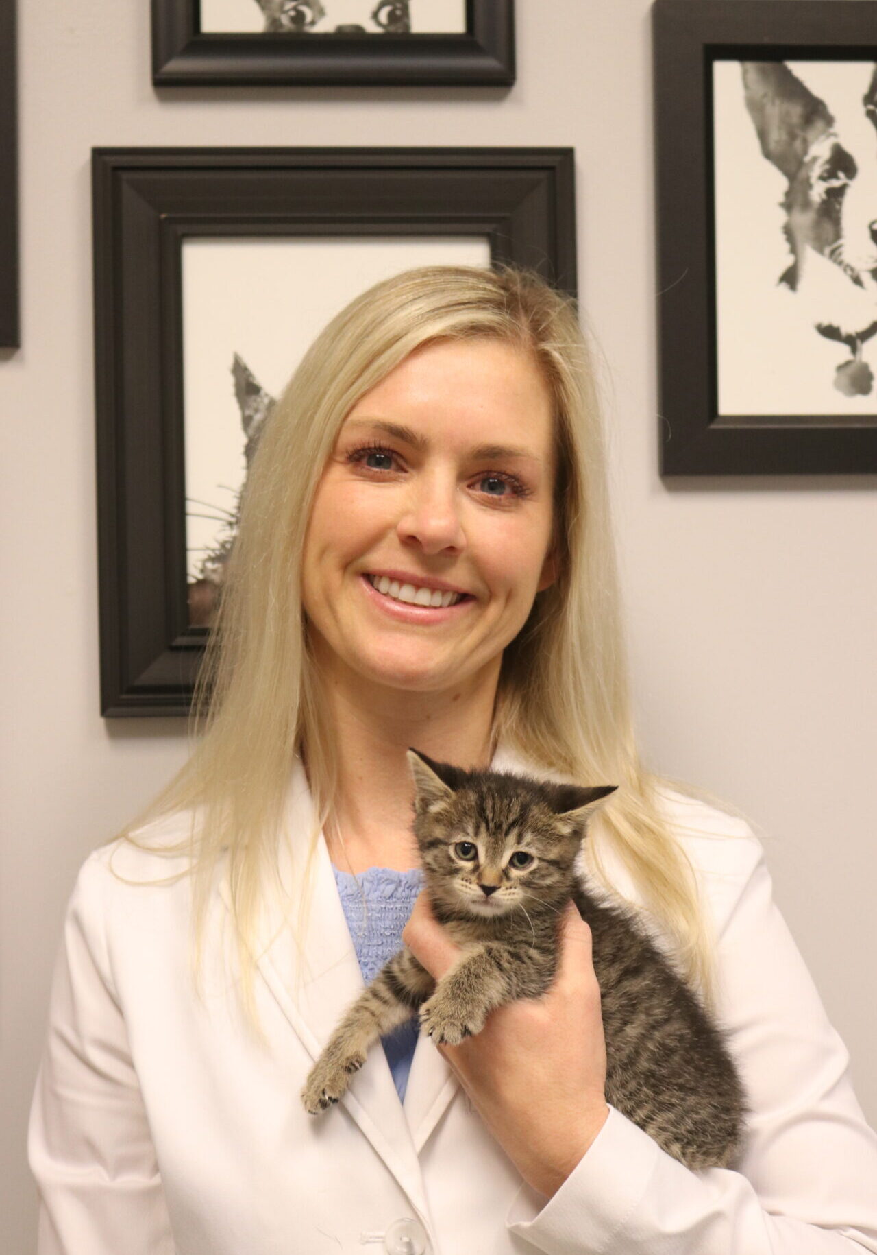 A woman holding a cat in her hand.