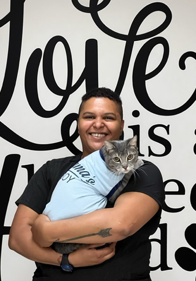 A woman holding a cat in her arms.