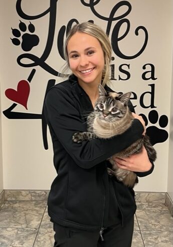 A woman holding a cat in her arms.